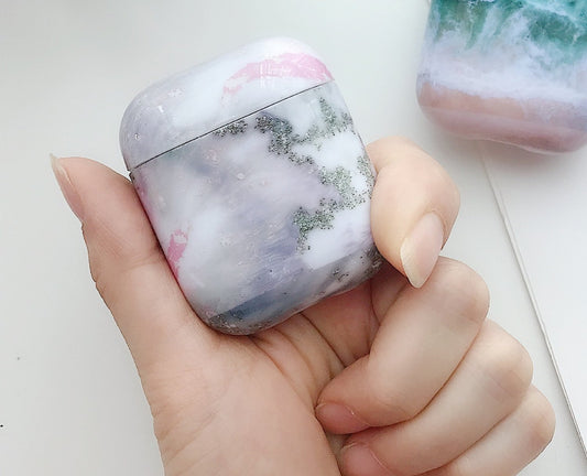 Beskyttelse for Airpods-deksler i rosa/grå marmormønster.