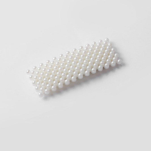 Hårspänne i metall dekorerad med pärlemorskimrande pärlor