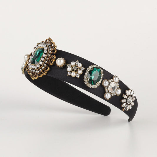 Luxurious diadem with precious stones and brooches emerald gold green black